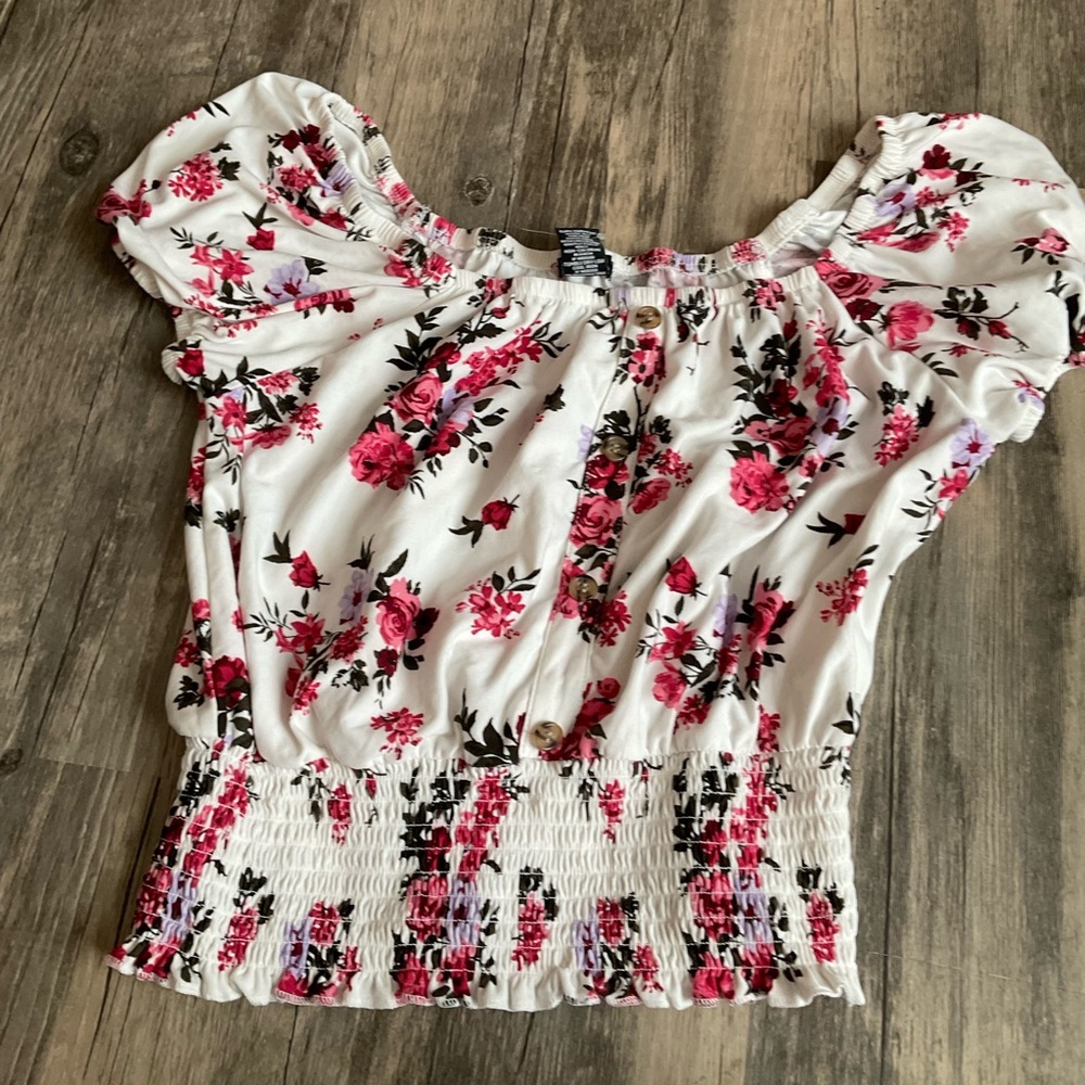 White shirt with e pink flowers, scrunch at the bottom of the shirt